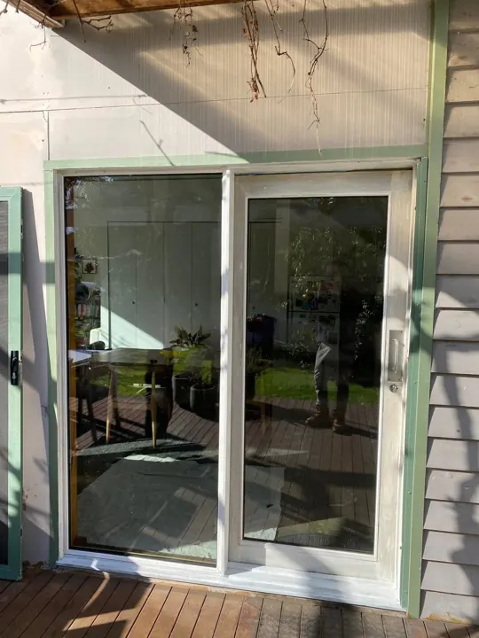 New sliding door with green timber trim